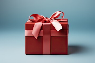 Obraz premium Red gift box on a blue background with a shiny ribbon.