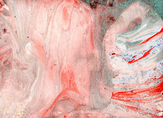 Abstract marble background of different shades of pink and gray. Red, green, blue splashes on the right side of the background. Colors mix with each other. They form different textures.