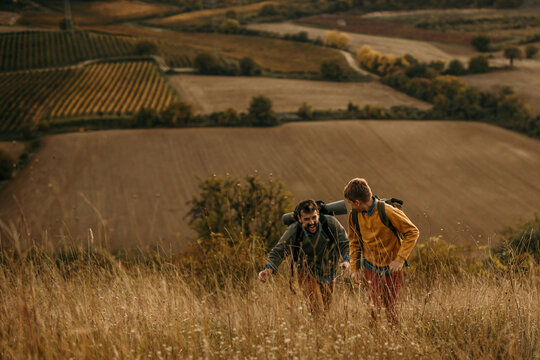 A father and his sone are hiking over the weekend in the mountains. They are relaxing in nature after a busy week.