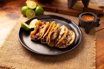 Suadero Tacos. Fried chopped meat in a mini corn tortilla. Street food from CDMX, Mexico, traditionally accompanied with cilantro, onion and spicy red sauce.