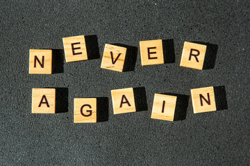 Never again wooden letters. Text on dark background