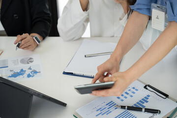 Group of Asian business men and women sitting and looking at documents at the office.