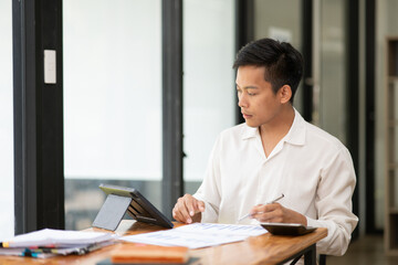 Asian businessman sitting and looking at documents at the office