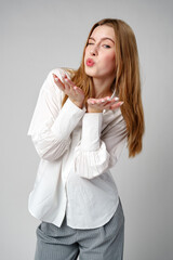 Young Woman Blowing a Kiss Towards the Camera in a Studio