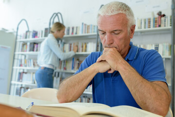 Fototapeta premium senior man with books in bookstore