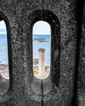 Phare sur les c&ocirc;tes bretonnes. Photo prise &agrave; travers le garde-corps d&rsquo;un autre phare.
