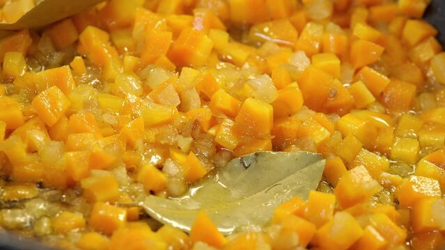 Preparation of carrot and leek saut&eacute; with bay leaf and olive oil.