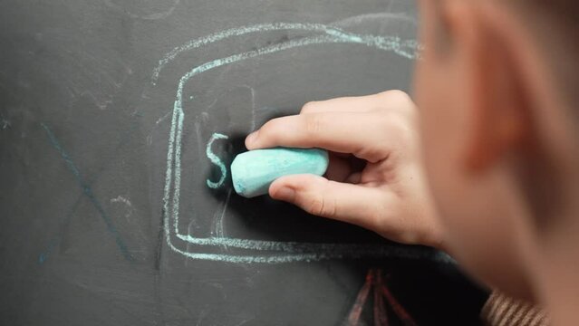 Closeup of smart student or boy hand writing prompt on blackboard. Child planing project and setting engineering system and brainstorm creative idea wrote on blackboard. Focus on hand. Erudition.