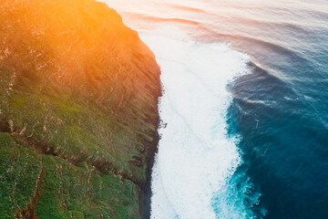 Aerial view of rough ocean with waves, volcanic beach, sunset over a huge cliff  in Lighthouse...