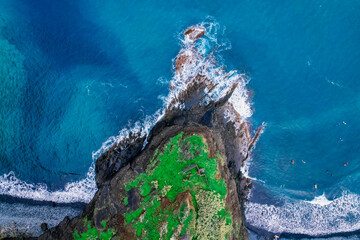 Aerial view of rough ocean with waves, volcanic beach in Porto da Cruz, Madeira, Portugal