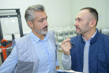 Obraz premium manual workers talking in a warehouse