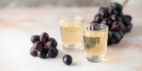Traditional Georgian  chacha, also known as grape vodka or Georgian grappa in shot glasses  and fresh grapes