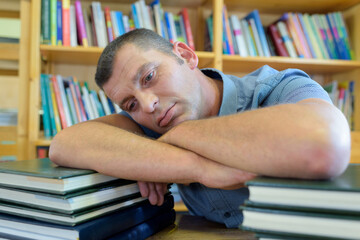 tired man with stack of books