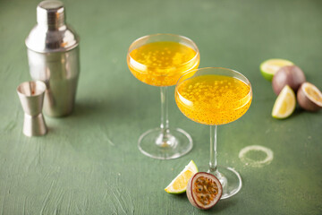 Passion fruit martini cocktail. Sour alcoholic drink with fresh passion fruit and lime, with bar tools.