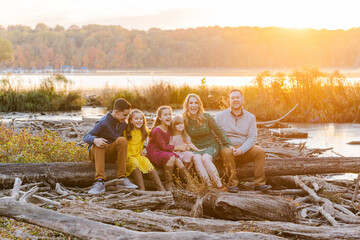 Family enjoying a joyful moment by the lake at sunset