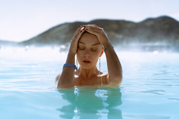 Woman relaxing in hot spring Blue Lagoon, Iceland.