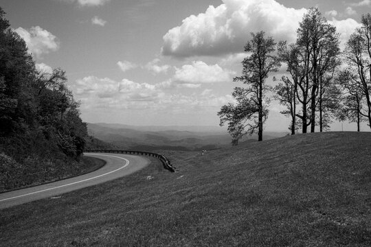 Blue ridge parkway curves through field with trees and view, Virginia
