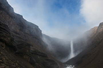 A massive waterfall called Litlanesfoss surrounded in columnar b