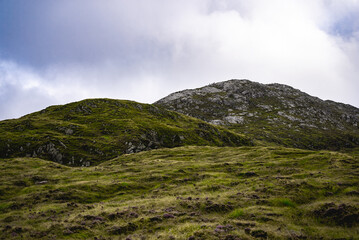 clouds over the mountains with hikers in the distance