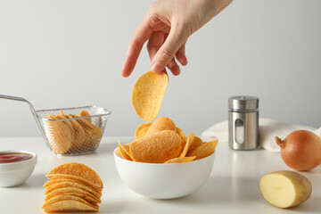 Potato chips in a bowl on a white table