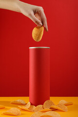 Potato chips with a red tube on a red background