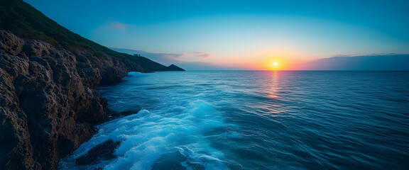 the sun setting over the ocean in a blue sky