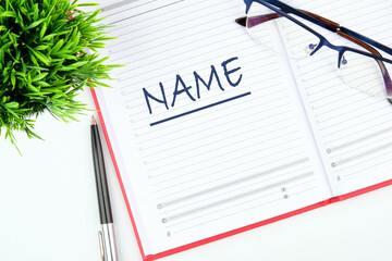 NAME word written in an open business notebook on a blank sheet