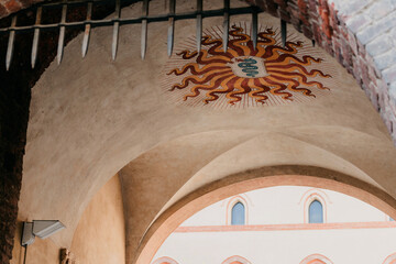 vibrant sun emblem with fiery rays over arched entrance