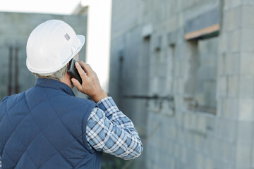 architect on building site using mobile phone