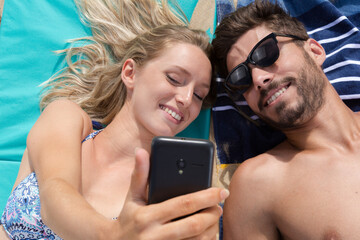 couple on the beach sharing holiday experience on social medial