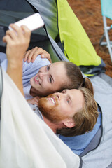 young couple in the tent taking selfie