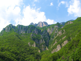 Naklejka premium Green mountains with blue sky and clouds