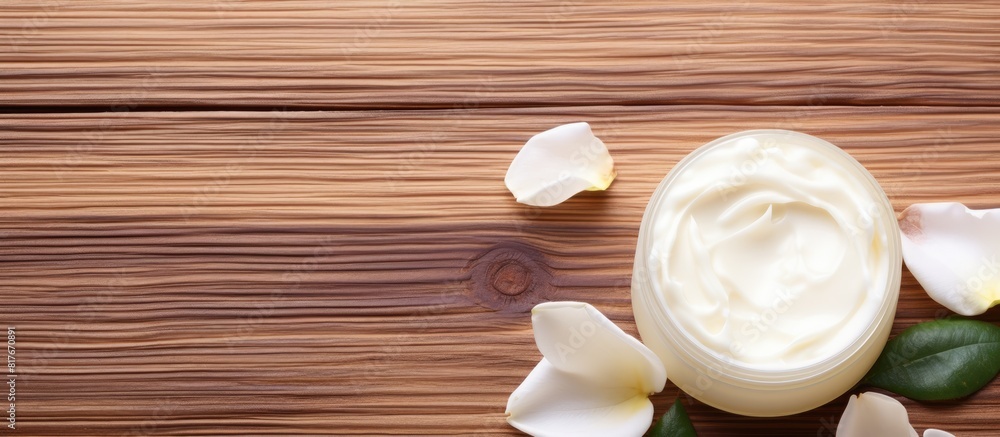 Aufkleber on a vibrant wooden table there is a cosmetic cream embellished with white rose petals a copy space 