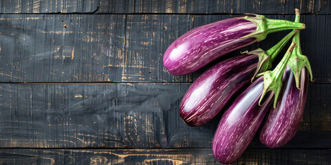 Eggplants on Weathered Wooden Background. A vibrant still life of fresh eggplants with a striking purple and white color palette arranged on a distressed dark wooden surface with copy space.