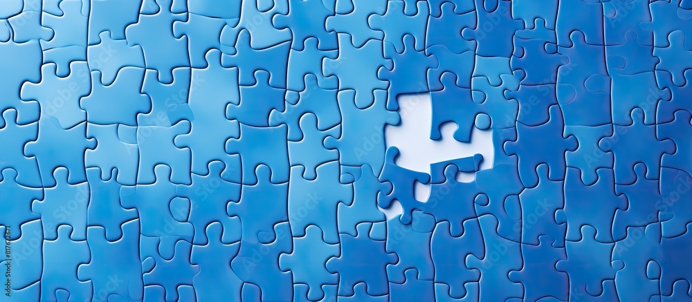 Poster A copy space image of an incomplete blue jigsaw puzzle seen from above against a lighter background