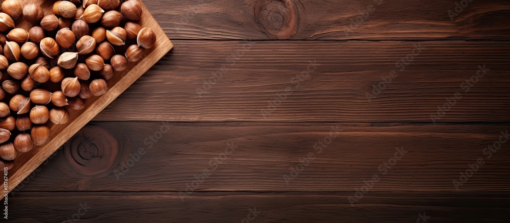 Poster A top down view of a wooden table with a plate holding a stack of hazelnuts creating a visually appealing copy space image