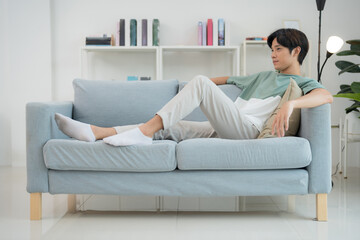 Young man relaxing on sofa in modern living room