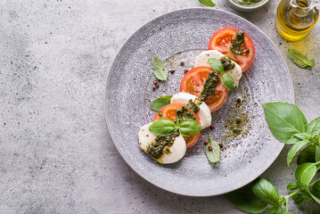 tomatoes with mozzarella with basil and pesto sauce