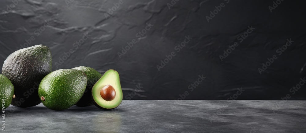 Poster a copy space image of mature avocados resting on a sleek grey textured surface