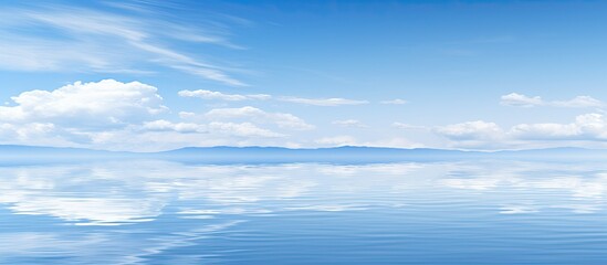 Obraz premium A serene scene with a clear blue sky mirrored in a calm blue ocean creating a captivating copy space image