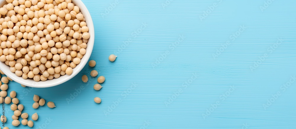 Poster A top down view of a bowl containing soy beans on a blue table with plenty of space for additional images