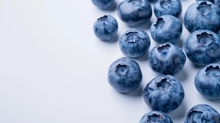 A close-up image of juicy fresh blueberries scattered on a pristine white surface, highlighting their natural texture and color