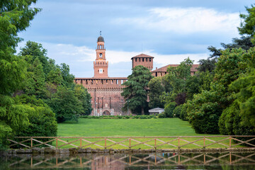 picturesque view of historic Sforza castle with tall towers, surrounded by lush greenery