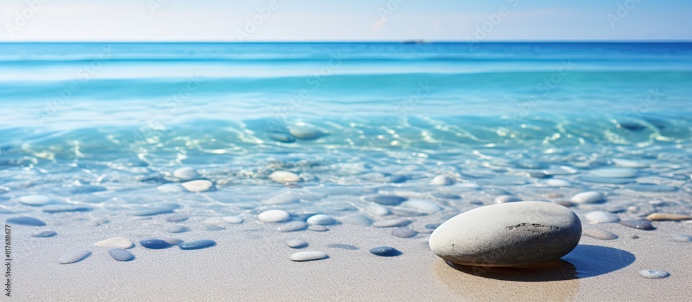Poster A pebble resting in the clear water on the sandy beach creating a serene and natural background for any desired content Copy space image