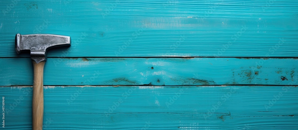 Aufkleber A close up top view of a hacksaw and hammer on a wooden turquoise background providing ample copy space for an image