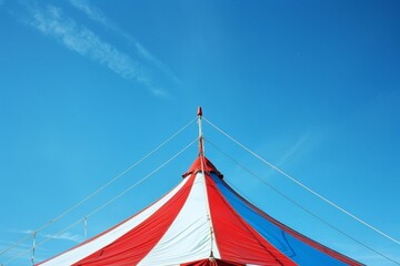 Blue and white striped circus tent under clear sky