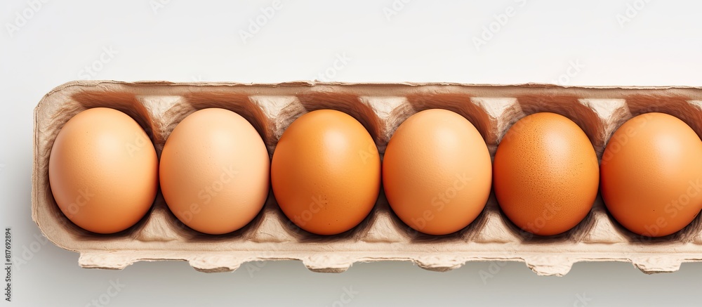 Poster close up of brown chicken eggs in an egg carton on a light background providing copy space for text 