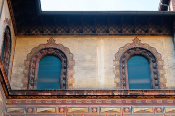 elaborately carved window frames on a richly patterned building facade with historic architectural details