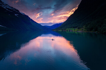 Fiery Sunset Aerial: Kayaker Gliding in Full Reflections on Norwegian Fjord