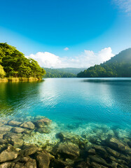 A beautiful lake with a clear blue water and a rocky shore